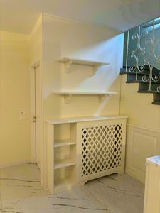 Boiserie sottoscala con termosifone, Boiserie sottoscala in legno laccato bianco